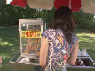 Amatieri pārsteidzošās seksuālā brunete skaistule selling pretzels uz the parck