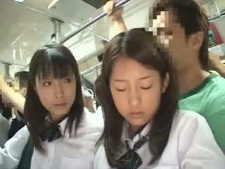 Two schoolgirls apgraibytas į a autobusas